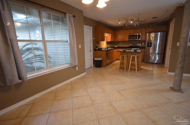 kitchen featuring a sink, dark countertops, appliances with stainless steel finishes, and baseboards
