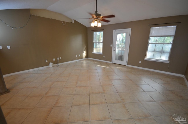 spare room featuring light tile patterned floors, ceiling fan, vaulted ceiling, and baseboards