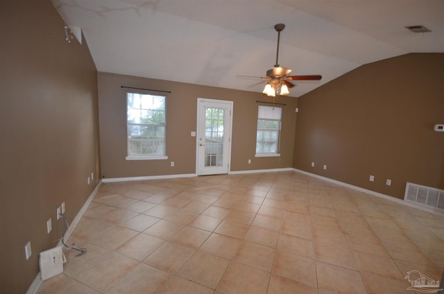 empty room featuring visible vents, ceiling fan, light tile patterned floors, and vaulted ceiling