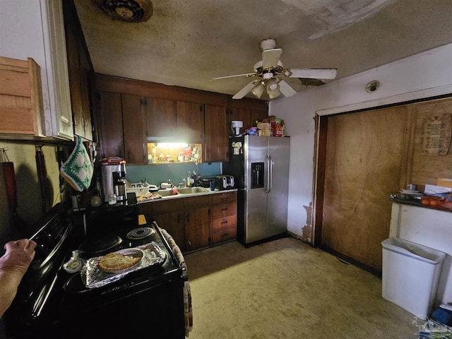 kitchen featuring a textured ceiling, stainless steel refrigerator with ice dispenser, black range with electric cooktop, ceiling fan, and sink