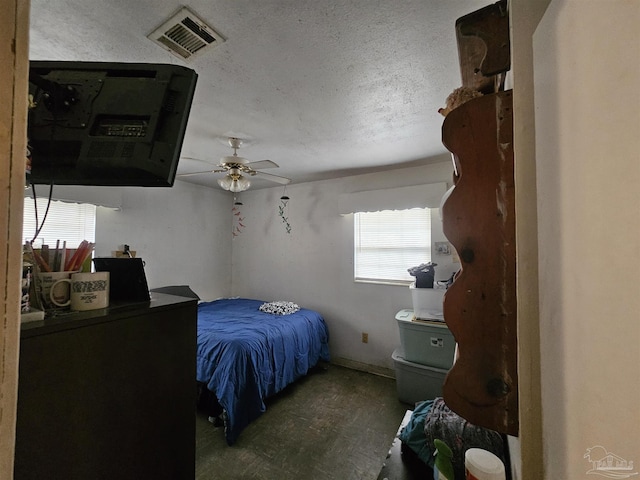 bedroom with a textured ceiling and ceiling fan