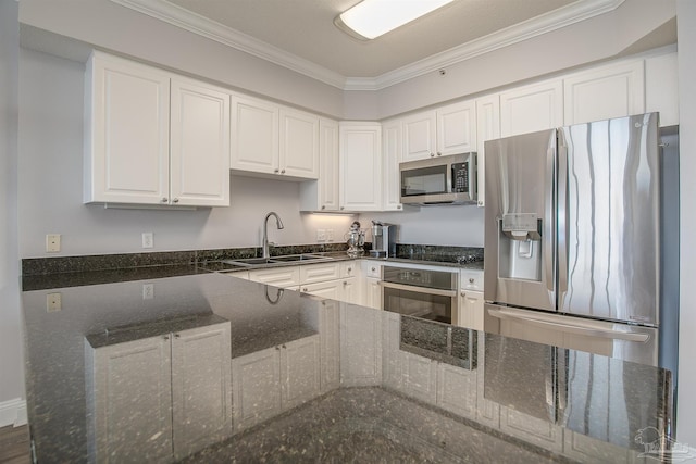 kitchen with dark stone counters, sink, ornamental molding, white cabinetry, and stainless steel appliances