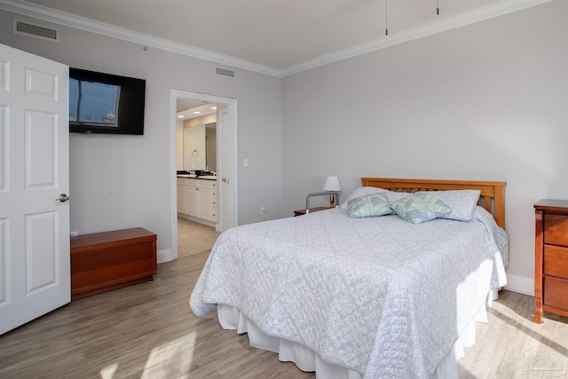 bedroom with connected bathroom, light hardwood / wood-style flooring, and ornamental molding