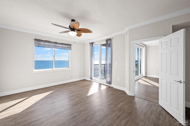 unfurnished room with a textured ceiling, ceiling fan, a water view, and crown molding