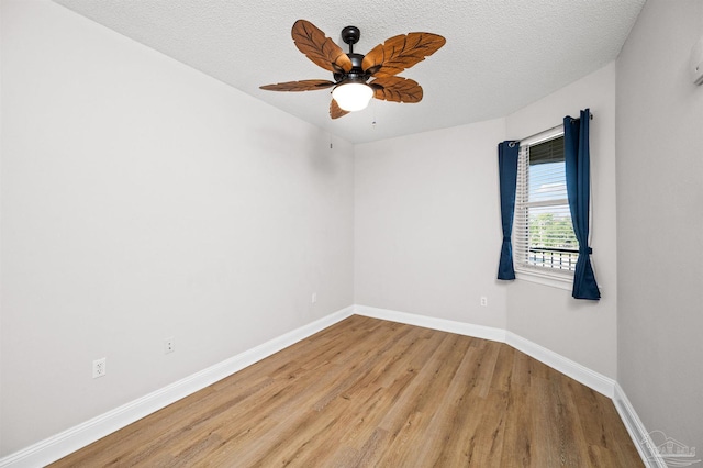 spare room with a textured ceiling, light hardwood / wood-style floors, and ceiling fan