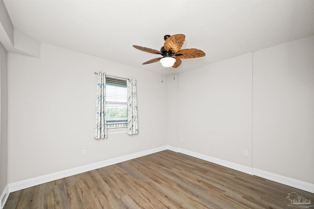 unfurnished room featuring ceiling fan, dark hardwood / wood-style flooring, and a textured ceiling