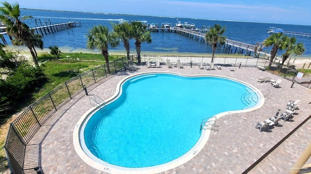 view of swimming pool featuring a water view and a patio