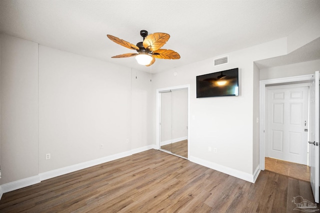 unfurnished room featuring ceiling fan, wood-type flooring, and a textured ceiling