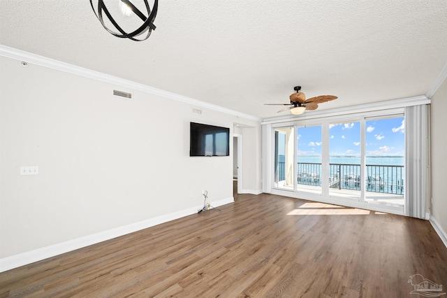 unfurnished living room featuring hardwood / wood-style flooring, ceiling fan, ornamental molding, and a textured ceiling