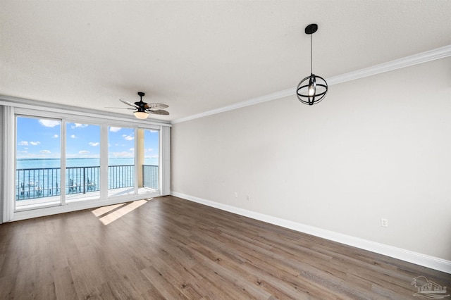 unfurnished room with crown molding, dark hardwood / wood-style flooring, a water view, and ceiling fan