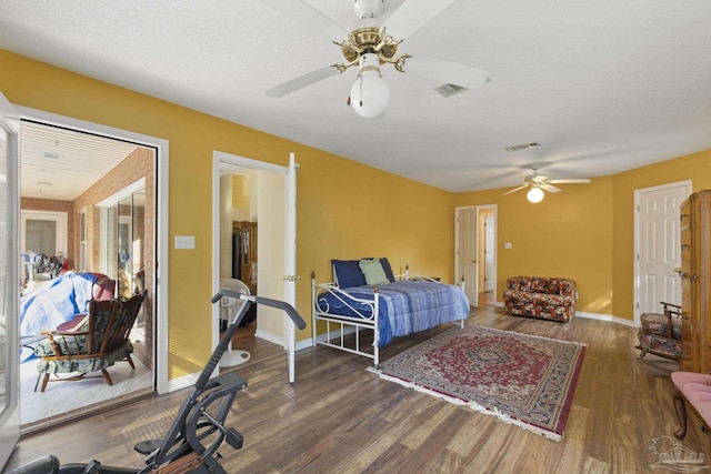 bedroom featuring dark hardwood / wood-style flooring, ceiling fan, and a textured ceiling