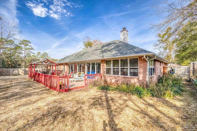 back of house with a deck and a lawn