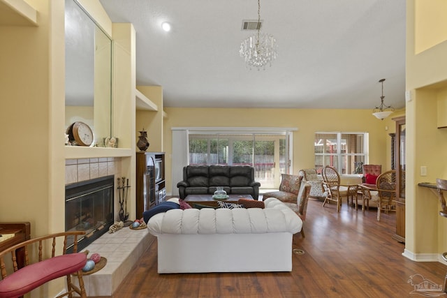 living room with a fireplace, hardwood / wood-style floors, and a notable chandelier