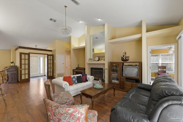 living room featuring lofted ceiling, dark hardwood / wood-style floors, a notable chandelier, and a fireplace