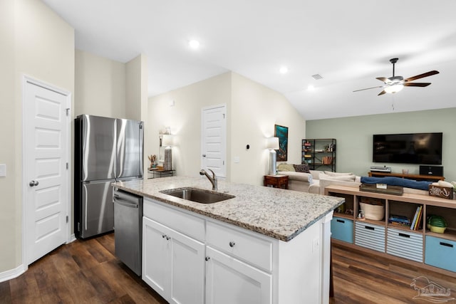 kitchen featuring light stone counters, stainless steel appliances, dark wood-type flooring, and a sink