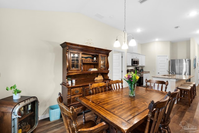 dining room featuring lofted ceiling, visible vents, dark wood-style flooring, and a chandelier