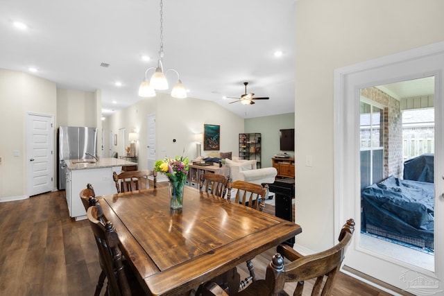 dining area with dark wood finished floors, vaulted ceiling, ceiling fan with notable chandelier, and baseboards