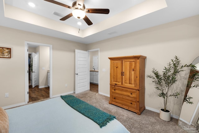 carpeted bedroom featuring recessed lighting, baseboards, a raised ceiling, and visible vents