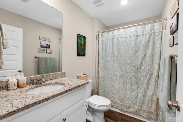 bathroom featuring vanity, a shower with curtain, wood finished floors, visible vents, and toilet