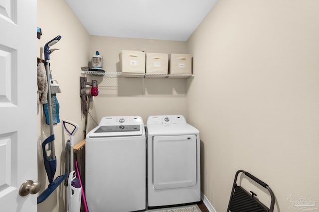 laundry area featuring laundry area, washing machine and dryer, and baseboards