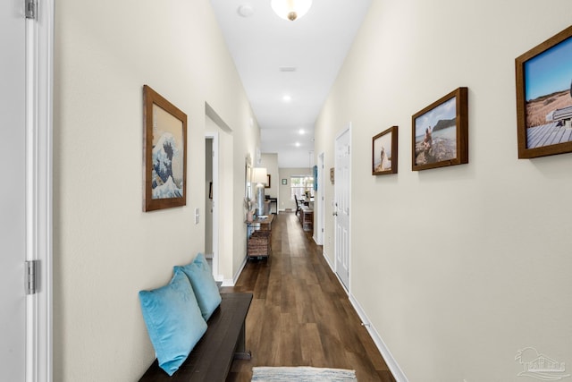 corridor featuring dark wood-type flooring, recessed lighting, and baseboards