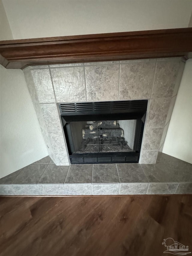 8156 Pompano St, Navarre, FL 32566 - details featuring a tiled fireplace and wood finished floors