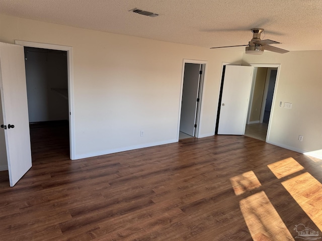 8156 Pompano St, Navarre, FL 32566 - unfurnished bedroom featuring baseboards, a textured ceiling, a spacious closet, and wood finished floors