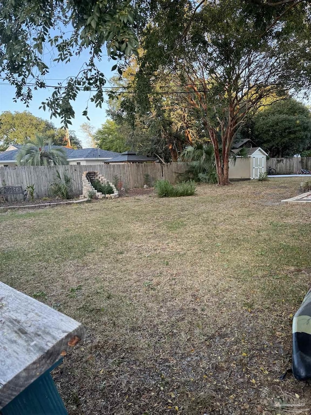 8156 Pompano St, Navarre, FL 32566 - view of yard with a storage unit, a fenced backyard, and an outdoor structure