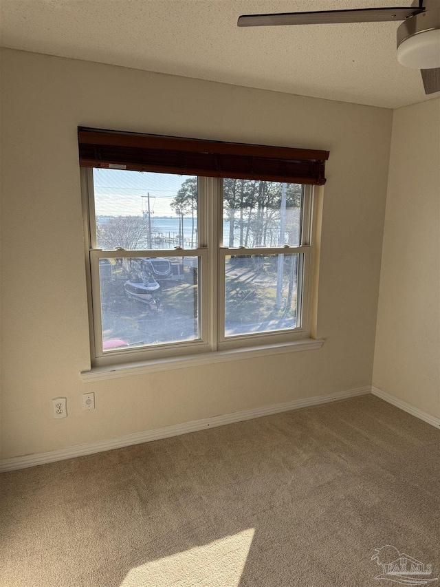 carpeted empty room featuring a textured ceiling