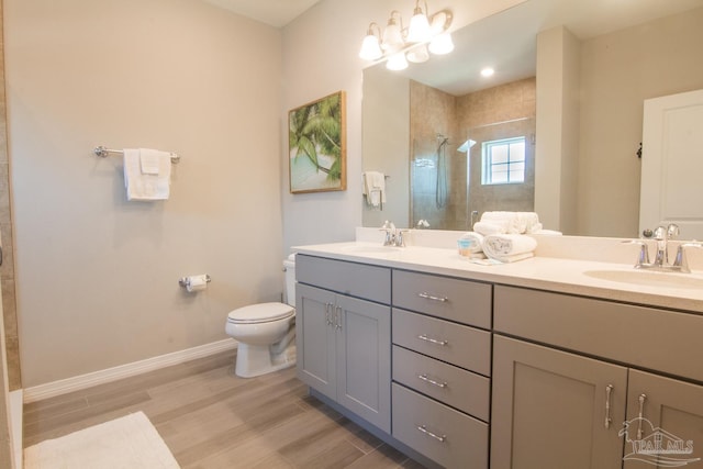 full bathroom with a tile shower, wood finished floors, a sink, and toilet