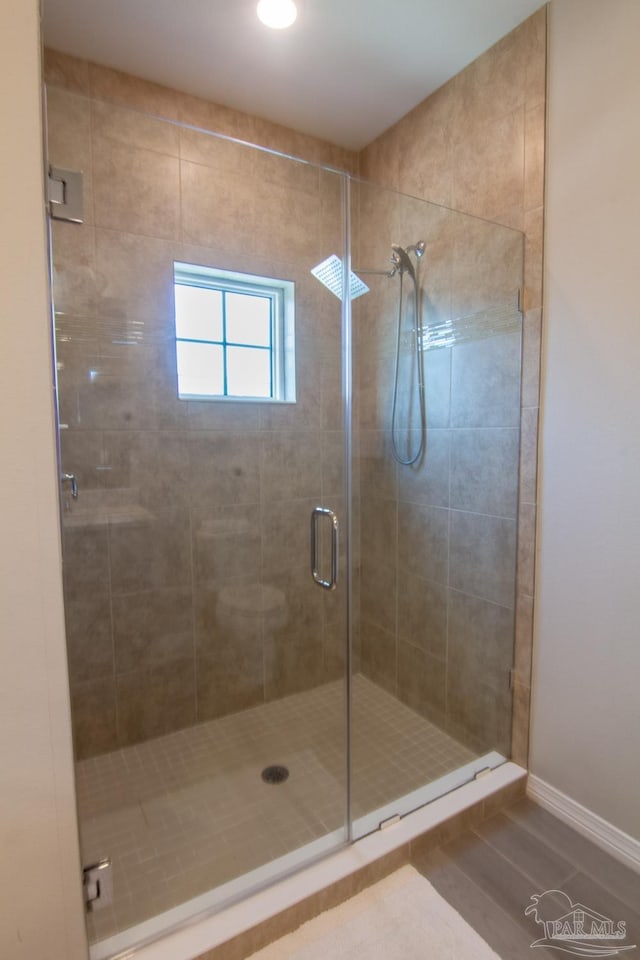 bathroom with tile patterned flooring, a shower stall, and baseboards