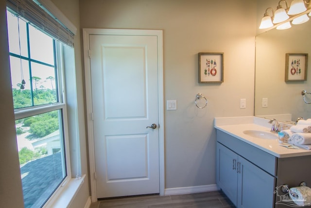 bathroom with baseboards, wood finished floors, and vanity