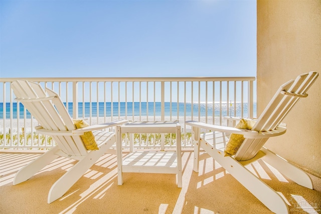 balcony with a water view and a view of the beach