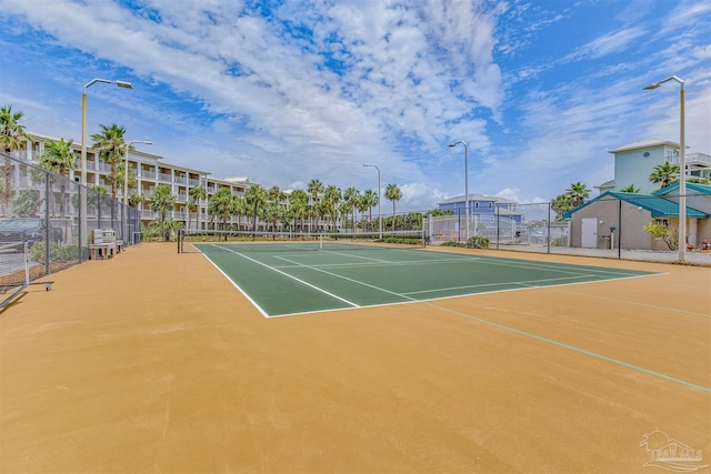 view of tennis court with community basketball court and fence