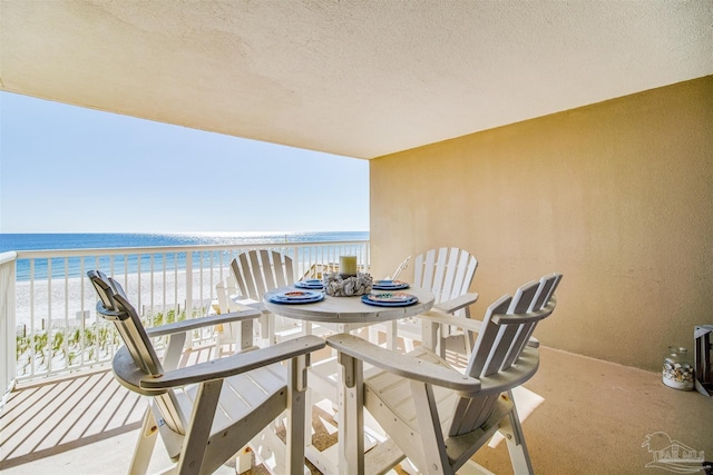 balcony with a water view and a view of the beach