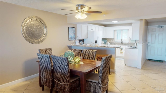 dining space featuring light tile patterned floors, baseboards, and a ceiling fan