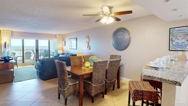 dining room with ceiling fan, baseboards, and light tile patterned floors