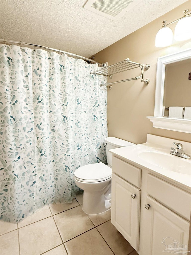 bathroom featuring visible vents, toilet, a textured ceiling, vanity, and tile patterned flooring