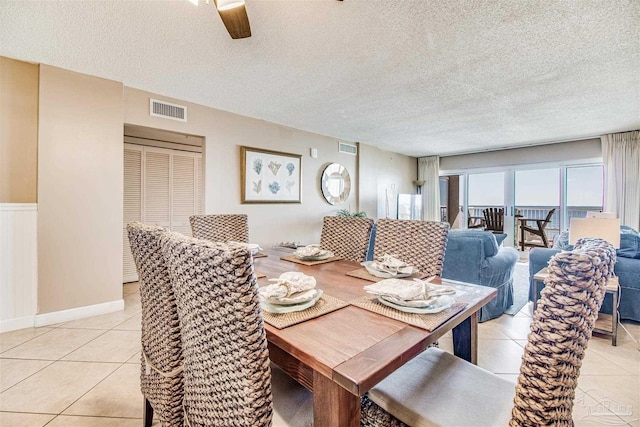 dining area with visible vents, ceiling fan, a textured ceiling, and light tile patterned floors