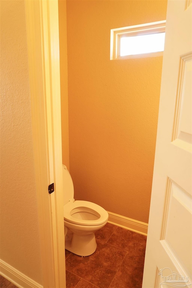 bathroom with toilet and tile patterned floors