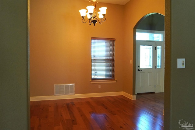 entryway featuring a healthy amount of sunlight, dark hardwood / wood-style flooring, and a chandelier