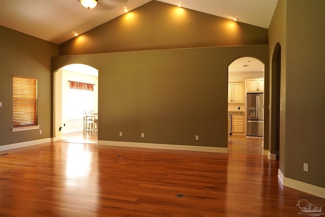 empty room featuring high vaulted ceiling and light hardwood / wood-style flooring