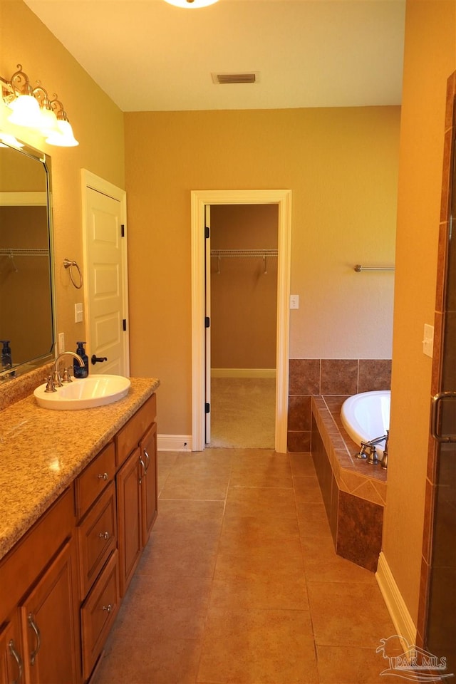 bathroom with independent shower and bath, vanity, and tile patterned floors