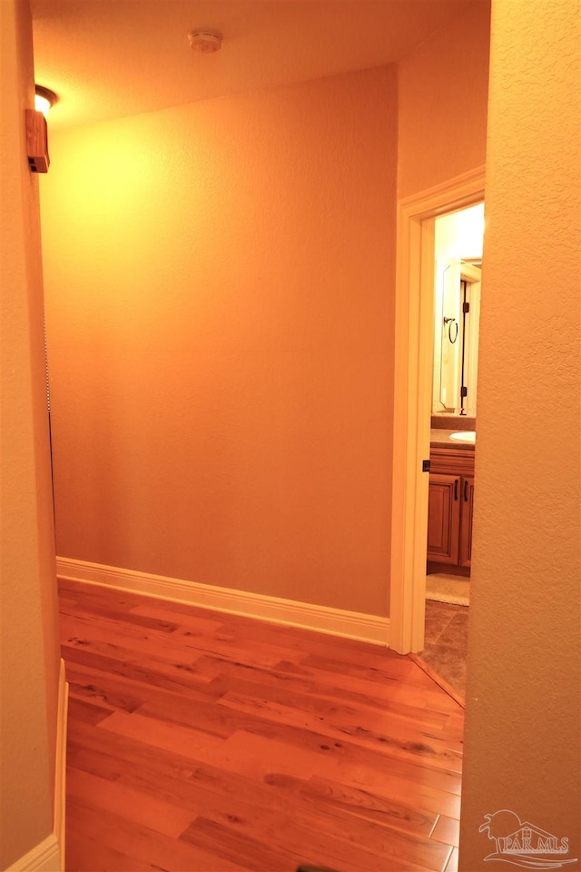 corridor with hardwood / wood-style floors