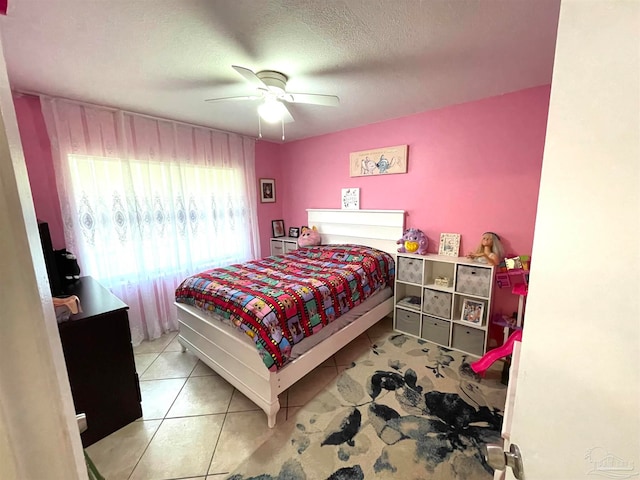 tiled bedroom featuring a textured ceiling and ceiling fan