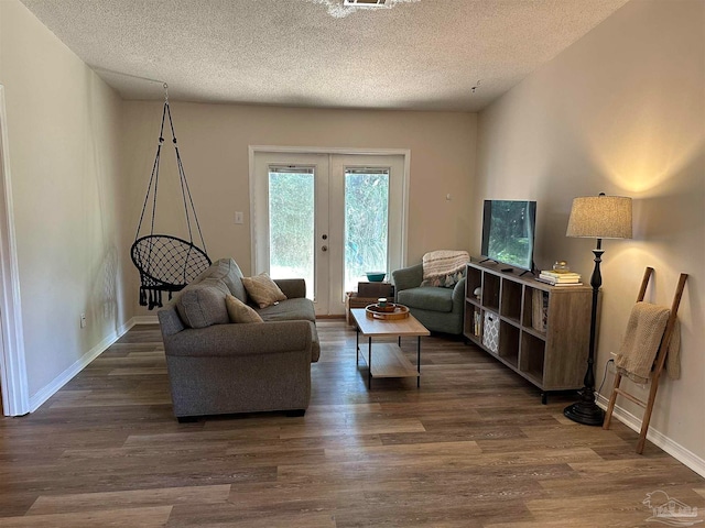 living room featuring french doors, a textured ceiling, and dark hardwood / wood-style floors