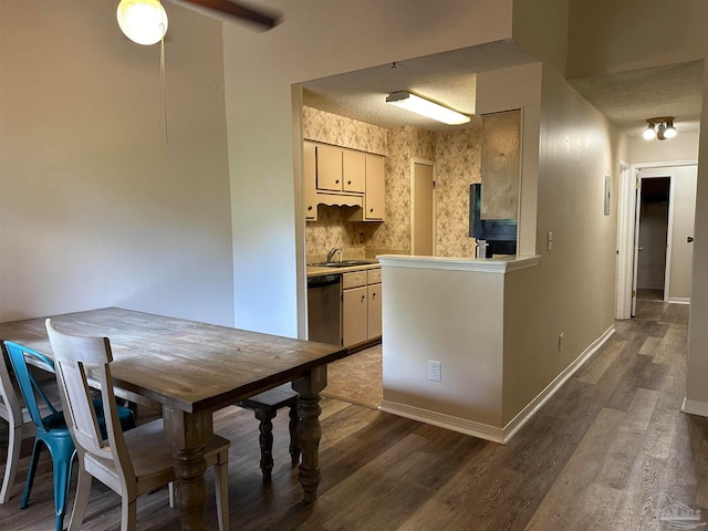 kitchen featuring a textured ceiling, dishwasher, sink, and dark hardwood / wood-style flooring