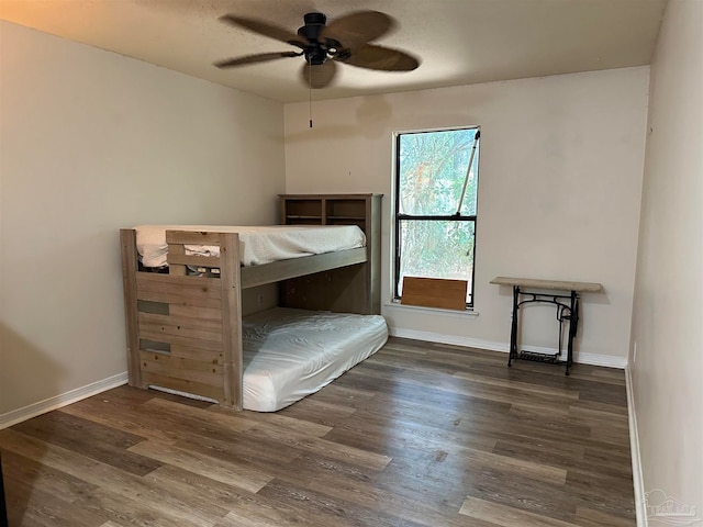 unfurnished bedroom featuring ceiling fan and dark wood-type flooring