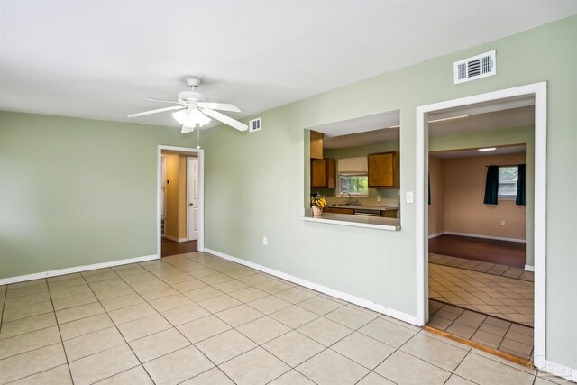 tiled empty room with sink and ceiling fan