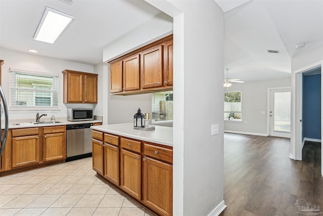 5397 Fawn Ridge Dr, Gulf Breeze, FL 32563 - kitchen with stainless steel appliances, brown cabinetry, light countertops, ceiling fan, and lofted ceiling